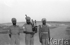 Maj 1942, Palestyna.
Trzej hinduscy żołnierze, w środku stoi kobziarz grający na kobzie.
Fot. Czesław Dobrecki, zbiory Ośrodka KARTA, Pogotowie Archiwalne [PAF_015], przekazał Krzysztof Dobrecki