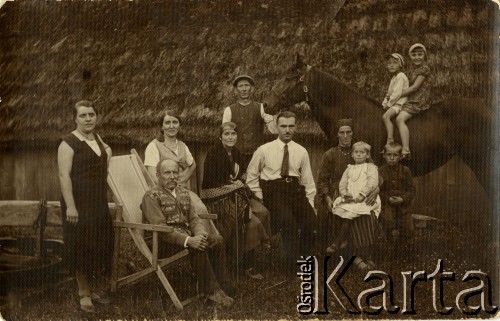1920-1930, brak miejsca, Polska.
Rodzina Stefana Niciewicza, dwoje dzieci siedzi na koniu. W tle widoczny jest drewniany budynek pokryty strzechą.
Fot. NN, zbiory Ośrodka KARTA, Pogotowie Archiwalne [PAF_018], udostępniła Stefania Sobczyk