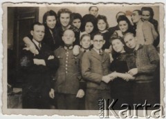 1944, Königsberg, Niemcy.
Robotnicy przymusowi z Polski, dziewczęta pracowały w zakładach Kocha przerabiających odzież przywożoną z obozów koncentracyjnych, dyrektorami zakładów byli oficerowie Necis i Beker. Na zdjęciu m.in. Barbara Zbrzyzna z Mławy, Krystyna Ruskówna z siostrą, z prawej stoi Wiesław z Płocka, drugi od lewej stoi Niemiec pilnujący dziewcząt. Podpis na odwrocie: 
