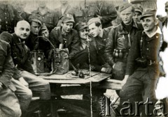 Kwiecień 1944, Lubelszczyzna, Polska.
Grupa żołnierzy Oddziałów Partyzanckich 9 Pułku Piechoty Armii Krajowej  podczas słuchania audycji radiowej. Pierwszy od lewej siedzi dowódca pułku major Stanisław Prus pseudonim 