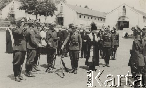 Lata 30-te, Polska.
Uroczystość wojskowa (przysięga?), grupa żołnierzy i oficerów Wojska Polskiego z szablami i karabinami oraz księża. Stanisław Sławikowski już jako emeryt, po cywilnemu, stoi z tyłu w środku, w ciemnym garniturze.
Fot. NN, zbiory Ośrodka KARTA, udostępniła Elżbieta Sławikowska