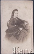 Ok. 1880, brak miejsca.
Joanna Podwińska (ok. 1825-1900) z domu Żukotyńska, żona Kajetana Podwińskiego, matka Felicji (żony Jordana, matki Zugmunta Klukowskiego). Kobieta jest ubrana w ciemny strój z szeroką spódnicą, ramiona ma okryte chustą.
Fot. NN, zbiory Ośrodka KARTA, udostępniła Joanna Majewska