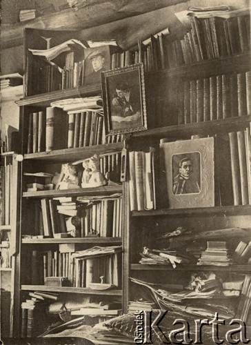 1924-1932, Kosów Poleski, woj. poleskie, Polska.
Biblioteczka księdza Feliksa Drozdowskiego - proboszcza parafii w Kosowie Poleskim. Na półce po prawej stoi portret papieża Benedykta XV, zaś na najwyższej półce zdjęcie ks. Drozdowskiego.
Fot. Feliks Drozdowski, zbiory Ośrodka KARTA, Pogotowie Archiwalne [PAF_050], udostępnił Krzysztof Drozdowski