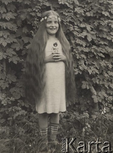 1924-1932, Kosów Poleski, woj. poleskie, Polska.
Dziewczynka z długimi włosami i w wianku na głowie trzymająca w rękach lalkę.
Fot. Feliks Drozdowski, zbiory Ośrodka KARTA, Pogotowie Archiwalne [PAF_050], udostępnił Krzysztof Drozdowski