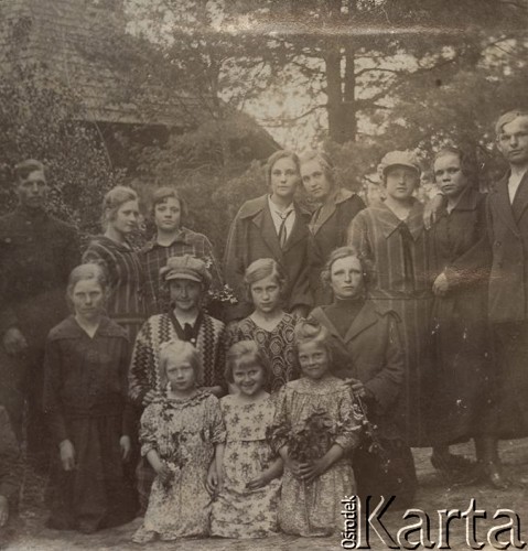 1924-1932, Kosów Poleski, woj. poleskie, Polska.
Grupa osób na tle drzew i budynku, na pierwszym planie trzy dziewczynki w letnich sukienkach.
Fot. Feliks Drozdowski, zbiory Ośrodka KARTA, Pogotowie Archiwalne [PAF_050], udostępnił Krzysztof Drozdowski