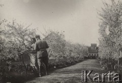 1924-1932, Kosów Poleski, woj. poleskie, Polska.
Kobieta i mężczyzna w mundurze, stojący obok kwitnącego drzewka przy drodze prowadzącej do domu.
Fot. Feliks Drozdowski, zbiory Ośrodka KARTA, Pogotowie Archiwalne [PAF_050], udostępnił Krzysztof Drozdowski