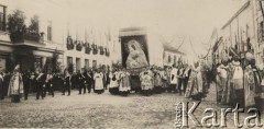 2.07.1927, Wilno, Polska.
Koronacja obrazu Matki Bożej Ostrobramskiej. Zdjęcie zostało wykonane podczas uroczystej procesji ulicami miasta, która odbyła się przed koronacją. Diakoni niosą obraz, wokół nich idą przedstawiciele korporacji studenckich, z przodu biskupi i arcybiskupi. Pierwszy z lewej strony jest widoczny prawdopodobnie Edward von Ropp (1851-1939), wcześniejszy biskup wileński i arcybiskup mohylewski, pierwsz z prawej Władysław Bandurski (1865-1932), biskup polowy Wojska Litwy Środkowej, dalej: Stanisław Okoniewski (1870-1944), biskup chełmiński, Adam Stefan Sapieha (1867-1951), arcybiskup metropolita krakowski i Romuałd Jałbrzykowski (1876-1955), arcybiskup wileński.
Fot. Feliks Drozdowski, zbiory Ośrodka KARTA, Pogotowie Archiwalne [PAF_050], udostępnił Krzysztof Drozdowski
