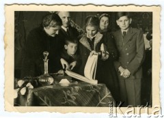 1945, Pruszków, Polska.
Jubileusz Leszka Majewskiego, stoją od lewej: Basia, Krzysztof, Renia (z opaską Czerwonego Krzyża) i Antek Majewscy, oglądający księgę pamiątkową. Z tyłu stoi Leszek Majewski i jego żona Maria Majewska.
Fot. NN, zbiory Ośrodka KARTA, kolekcję udostępniła Barbara Majewska-Luft