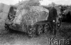 Lato 1944, Białoruś, ZSRR.
Letnia ofensywa Armii Czerwonej - radziecki żołnierz stojący obok zdobytego niemieckiego pojazdu pancernego zamaskowanego gałęziami.
Fot. Aleksiej Pamiatnych (ojciec), udostępnił Aleksiej Pamiatnych, zbiory Ośrodka KARTA
