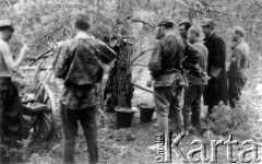 24.07.1944, Puszcza Nacka, okolice Jocz, pow. Wileńsko-Trocki.
Oddział partyzancki Bazy z Kedywu Komendy Okręgu Wileńskiego AK. Biwak nad rzeką Wohubką na przeciwko Jocz. Suczenie ubrań, jedzenie i odpoczynek po wyczerpującym nocnym marszu.
Fot. Zygmunt Zniszczyński, zbiory Ośrodka KARTA, kolekcja BAZY-MIÓD [sygn. 7/19?]

