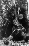 Koniec lipca 1944, Puszcza Grodzieńska, pow. Grodno.
Oddział partyzancki Bazy z Kedywu Komendy Okręgu Wileńskiego AK na biwaku w puszczy. Plut. Jan Nasutto 