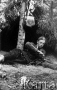 Koniec lipca 1944, Puszcza Grodzieńska, pow. Grodno.
Oddział partyzancki Bazy z Kedywu Komendy Okręgu Wileńskiego AK na biwaku w puszczy. Plut. Jan Nasutto 