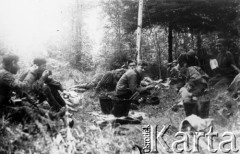 Koniec lipca 1944, Puszcza Nacka, pow. Wilno-Troki.
Oddział partyzancki Bazy z Kedywu Komendy Okręgu Wileńskiego AK. Posiłek na biwaku. Z prawe leży (bez nakrycia głowy) plut. pchor. Andrzej Święcicki 