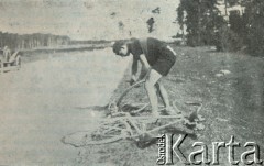 Lata 30-te, woj. mazowieckie, Polska.
Kazimierz Duszyński naprawia rower w czasie wyścigu Expressu Porannego.   
Fot. NN, zbiory Ośrodka Karta, udostępniło Warszawskie Towarzystwo Cyklistów (WTC).