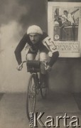 1913, Polska pod zaborem rosyjskim.
Feliks Rawski na rowerze. Zdjęcie pozowane w atelier fotograficznym. W tle, na ścianie  plakat w języku rosyjskim reklamujący Pierwszą rosyjską Olimpiadę w 1913 roku.
Fot. NN, zbiory Ośrodka Karta, udostępniło Warszawskie Towarzystwo Cyklistów (WTC).