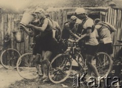 1935, Polska.
Punkt regeneracyjny podczas wyścigu rowerowego. Kolarze na rowerach piją wodę bezpośrednio z wiader. 
Fot. NN, zbiory Ośrodka Karta, udostępniło Warszawskie Towarzystwo Cyklistów (WTC).