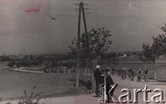 1948, Czechosłowacja.
Wyścig kolarski na trasie Praga-Warszawa. Etap Brno-Zlin o długości 137 km. Na zdjęciu na pierwszym planie kilkoro widzów obserwujących przejeżdżającyh szosą kolarzy w sportowych strojach. Na dalszym planie obsługa techniczna w samochodach i autobusie. W tle zabudowania Brna.
Fot. NN, zbiory Ośrodka Karta, udostępniło Warszawskie Towarzystwo Cyklistów (WTC).

