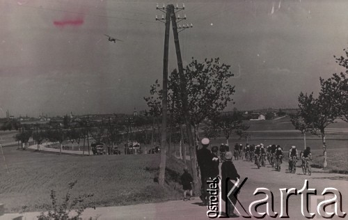 1948, Czechosłowacja.
Wyścig kolarski na trasie Praga-Warszawa. Etap Brno-Zlin o długości 137 km. Na zdjęciu na pierwszym planie kilkoro widzów obserwujących przejeżdżającyh szosą kolarzy w sportowych strojach. Na dalszym planie obsługa techniczna w samochodach i autobusie. W tle zabudowania Brna.
Fot. NN, zbiory Ośrodka Karta, udostępniło Warszawskie Towarzystwo Cyklistów (WTC).

