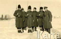 Zima 1940, Targu-Jiu, Rumunia.
Obóz internowania żołnierzy Wojska Polskiego - żołnierze w drodze do dentysty. Rumuńska eskorta w czapkach futrzanych i zimowych płaszczach, na pasie dwie ładownice, karabin Mosin wz. 1891 z nałożonym na lufę bagnetem; Polacy, od lewej: ppor. pilot Adam Rotszyld w mundurze służbowym i czapce garnizonowej, kpt. pilot Tadeusz Krajewski w mundurze służbowym i berecie, na płaszczu pas główny wz. 36 bez szelki naramiennej, ppor. pilot NN w mundurze służbowym. 
 Fot. NN, zbiory Ośrodka Karta, album (A-XIII). Zdjęcie ze zbioru ocalonego przez pracownika ambasady PRL w Bukareszcie Jerzego Polakowskiego
   
