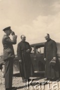 1940, Comisani, Rumunia.
Obóz internowania dla żołnierzy Wojska Polskiego - wizyta zastępcy nuncjusza papieskiego. Na zdjęciu od lewej: polski komendant obozu w Comisani, podpułkownik dypl. pilot Olgierd Tuskiewicz oddający honory wojskowe; z prawej obok samochodu stoi Delegat Nuncjusza Apostolskiego dla Uchodźców Polskich w Rumunii o. Stanisław Skudrzyk; w środku kapelan obozowy ks. Ziółkowski.
 Fot. NN, zbiory Ośrodka Karta, album (A-XII). Zdjęcie ze zbioru ocalonego przez pracownika ambasady PRL w Bukareszcie Jerzego Polakowskiego
   
