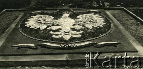 1940, Comisani, Rumunia.
Obóz dla internowanych żołnierzy Wojska Polskiego. Mozaika o rozmiarach 4x6 m przedstawiająca orła polskiego w koronie, z datą 1939, wykonana przez polskich żołnierzy.
 Fot. NN, zbiory Ośrodka Karta, album (A-XII). Zdjęcie ze zbioru ocalonego przez pracownika ambasady PRL w Bukareszcie Jerzego Polakowskiego
   
