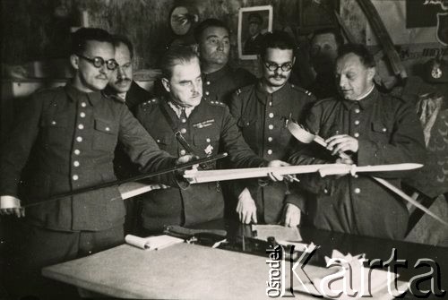 1940, Comisani, Rumunia.
Obóz internowania dla żołnierzy Wojska Polskiego, pracownicy Referatu Kulturalno-Oświatowego oglądają rekwizyty do sztuki Józefa Bzowskiego 