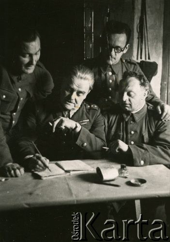 1940, Comisani, Rumunia.
Obóz internowania dla żołnierzy Wojska Polskiego, szef Referatu Kulturalno-Oświatowego kpt. Józef Bzowski i współpracownicy: z prawej Artur Szwarcbrot-Malinowicz, z tyłu Władysław Schimseleiner i Tadeusz Kustanowicz (z lewej).
 Fot. NN, zbiory Ośrodka Karta, album (A-XII). Zdjęcie ze zbioru ocalonego przez pracownika ambasady PRL w Bukareszcie Jerzego Polakowskiego
   
