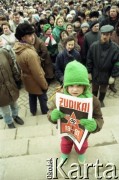 Styczeń 1991, Wilno, Litwa.
Tłum w centrum miasta, na pierwszym planie dziewczynka z plakatem odnoszącym się do interwencji wojsk radzieckich. 
Fot. Wojciech Druszcz, zbiory Ośrodka KARTA
