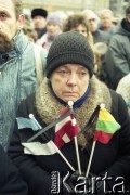 Styczeń 1991, Wilno, Litwa.
Miasto po interwencji wojsk radzieckich. Tłum mieszkańców zgromadzony w centrum miasta, na pierwszym planie kobieta z flagami Litwy, Łotwy i Estonii. 
Fot. Wojciech Druszcz, zbiory Ośrodka KARTA