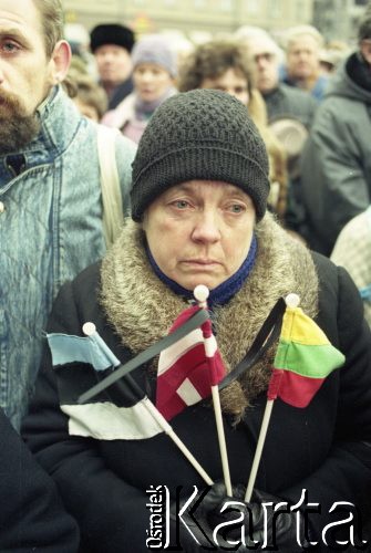 Styczeń 1991, Wilno, Litwa.
Miasto po interwencji wojsk radzieckich. Tłum mieszkańców zgromadzony w centrum miasta, na pierwszym planie kobieta z flagami Litwy, Łotwy i Estonii. 
Fot. Wojciech Druszcz, zbiory Ośrodka KARTA