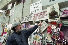 Styczeń 1991, Wilno, Litwa.
Mężczyzna przed umocnieniami otaczającymi parlament z przywieszonymi transparentami i plakatami z hasłami wolnościowymi.
Fot. Wojciech Druszcz, zbiory Ośrodka KARTA