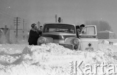 Luty 1971, okolice Kamionki, województwo warszawskie, Polska.
Karetka pogotowia w zaspie. Lekarze i pielęgniarka usiłują przepchnąć ją przez zasypaną śniegiem drogę, aby dotrzeć do chorego. 
Fot. Wojciech Druszcz, zbiory Ośrodka KARTA