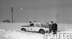 Luty 1971, okolice Kamionki, województwo warszawskie, Polska.
Karetka pogotowia w zaspie. Lekarze i pielęgniarka usiłują przepchnąć ją przez zasypaną śniegiem drogę, aby dotrzeć do chorego. 
Fot. Wojciech Druszcz, zbiory Ośrodka KARTA