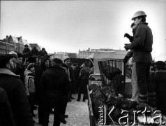 15.12.1981, Gdańsk, Polska.
Plac Solidarności. Wprowadzenie stanu wojennego - robotnicy Stoczni Gdańskiej im. Lenina dostarczają koks do koksowników zmarzniętym żołnierzom z czołgów, stacjonujących pod Stocznią. W tym samym czasie trwa strajk okupacyjny na terenie Stoczni przeciwko wprowadzeniu stanu wojennego.
Fot. Leszek Pękalski, zbiory Ośrodka KARTA