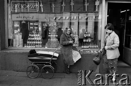 Lata 70., Bytom, woj. katowickie, Polska.
Babuleńka sprzedająca czosnek przed sklepem Społem.
Fot. Joanna Helander, zbiory Ośrodka KARTA