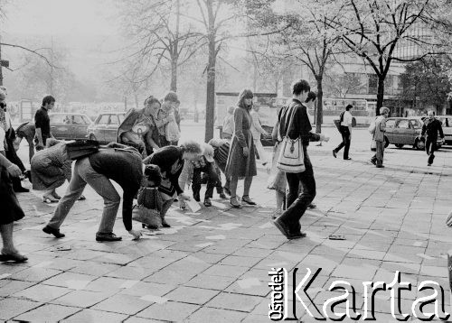 1982-1983, Warszawa, Polska.
Stan wojenny, ludzie zbierają z chodnika rozrzucone ulotki.
Fot. Anna Pietuszko, zbiory Ośrodka KARTA