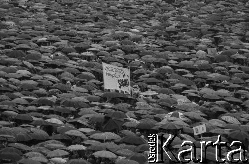 19.06.1983, Częstochowa, Polska.
Druga pielgrzymka papieża Jana Pawła II do Polski. Tłum pod parasolami podczas mszy świętej celebrowanej przez Ojca Świętego, widoczny transparent o treści: 