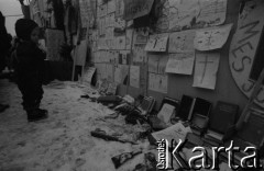 Styczeń 1991, Wilno, Litwa.
Dziecko przy umocnieniach otaczających budynek Sejmu. Na ogrodzeniu plakaty, poniżej leżą książki i broń.
Fot. Anna Pietuszko, zbiory Ośrodka KARTA