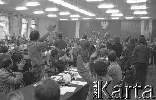 Sierpień 1980, Gdańsk, Polska.
Strajk okupacyjny w Stoczni Gdańskiej im. Lenina. Obrady strajkujących załóg w sali BHP. Za stołem prezydialnym z uniesionymi rękami stoi Lech Wałęsa.
Fot. Zbigniew Trybek, zbiory Ośrodka KARTA

