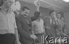 26.08.1980, Gdańsk, Polska.
Strajk okupacyjny w Stoczni Gdańskiej im. Lenina. Zebranie w sali BHP. Lech Wałęsa ze strajkującymi, trzyma plik banknotów, 2. z prawej Florian Wiśniewski, w środku Claude Sardais z francuskiego związku CFDT, który odwiedził Stocznię Gdańską i zadeklarował poparcie dla strajkujących oraz przekazał 11 tys. franków francuskich.
Fot. Zbigniew Trybek, zbiory Ośrodka KARTA


