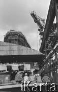 3.10.1980, Gdańsk, Polska.
Pracownicy Stoczni Gdańskiej biorą udział w ogólnopolskim, jednogodzinnym strajku ostrzegawczym. Na zdjęciu stoczniowcy siedzą na nabrzeżu, w tle dźwigi i stoczniowcy na kadłubie okrętu.
Fot. Zbigniew Trybek, zbiory Ośrodka KARTA
