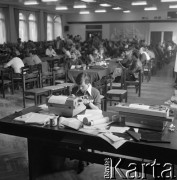 Sierpień 1980, Gdańsk, Polska.
Strajk okupacyjny w Stoczni Gdańskiej im. Lenina. Mężczyzna pisze na maszynie, w tle ludzie siedzący przy stołach.
Fot. Zbigniew Trybek, zbiory Ośrodka KARTA