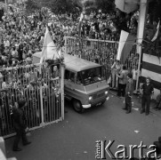 Sierpień 1980, Gdańsk, Polska.
Strajk okupacyjny w Stoczni Gdańskiej im. Lenina. Przez bramę przejeżdża żuk, w tyle tłum ludzi.
Fot. Zbigniew Trybek, zbiory Ośrodka KARTA