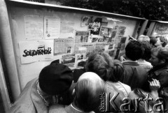 Sierpień 1980, Gdańsk, Polska.
Strajkujący robotnicy Stoczni Gdańskiej im. Lenina pod tablicą informacyjną, m.in. z artykułami z prasy zagranicznej, dotyczącymi wydarzeń na Wybrzeżu.
Fot. Stanisław Składanowski, zbiory Ośrodka KARTA