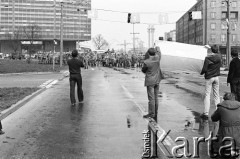 1.05.1982, Gdańsk, Polska.
Stan wojenny. Ulice Gdańska w dniu starć ulicznych opozycjonistów i milicji - demonstranci z flagą, w głębi kordon milicji i samochód z armatkami wodnymi.
Fot. Stanisław Składanowski, zbiory Ośrodka KARTA
