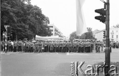 18-19.06.1983, Częstochowa, Polska.
Druga pielgrzymka Jana Pawła II do Polski, grupa milicjantów na ulicy, za nimi tłum wiernych z transparentami.
Fot. Jerzy Szot, zbiory Ośrodka KARTA