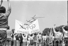 22.06.1983, Kraków, Polska.
Druga pielgrzymka Jana Pawła II do Polski. Na zdjęciu papieski helikopter podchodzi do lądowania na krakowskich Błoniach, wierni witają i pozdrawiają papieża. Po prawej transparent z napisem: 