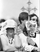 10.06.1987, Kraków, Polska.
Trzecia pielgrzymka Jana Pawła II do Polski. Wierni podczas mszy świętej na Błoniach celebrowana przez Ojca Świętego, na pierwszy planie kobieta i mężczyzna w komży z krzyżem.
Fot. Jerzy Szot, zbiory Ośrodka KARTA