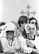 10.06.1987, Kraków, Polska.
Trzecia pielgrzymka Jana Pawła II do Polski. Wierni podczas mszy świętej na Błoniach celebrowana przez Ojca Świętego, na pierwszy planie kobieta i mężczyzna w komży z krzyżem.
Fot. Jerzy Szot, zbiory Ośrodka KARTA