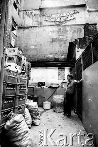 1989, Polska.
Mężczyzna na dziedzińcu kamienicy. Nad nim napis: 